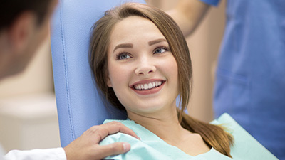 Smiling young woman in dental exam room