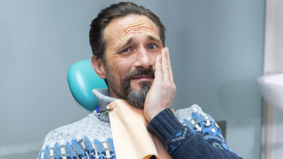 Pained man visiting his Irving emergency dentist