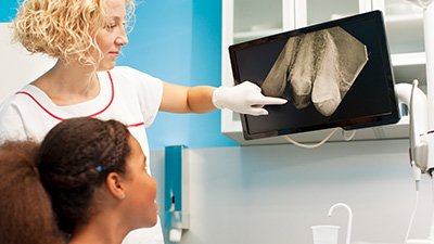 Dentist and patient looking at digital radiography