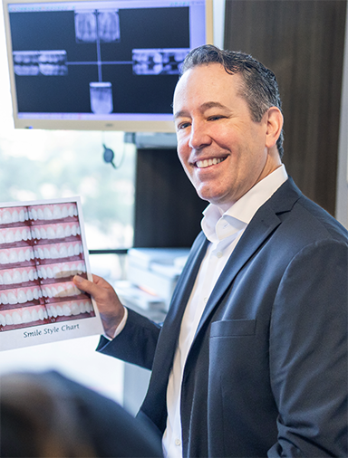 Doctor Roy showing a patient photos of teeth