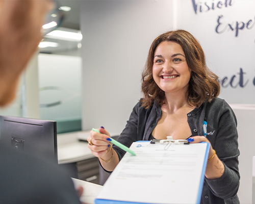 Dental staff member showing a clipboard to a patient