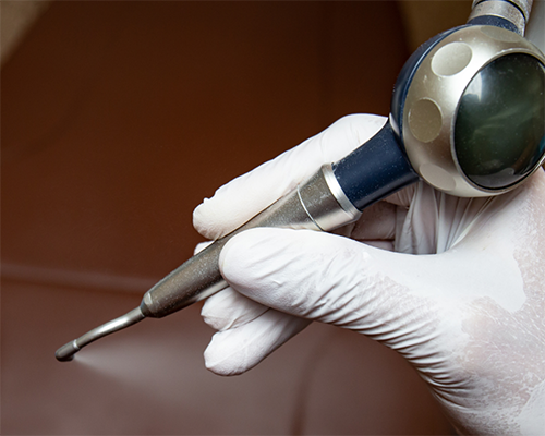 Dentist holding a pen-like tool