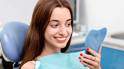 Woman looking at smile in mirror