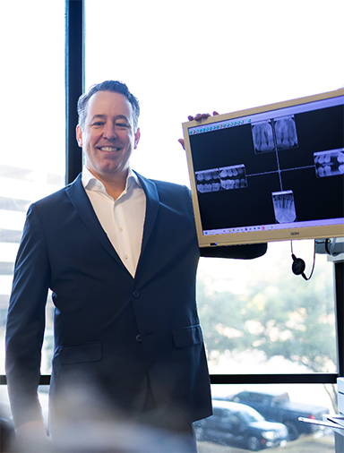 Doctor Roy showing a patient x-rays of their teeth