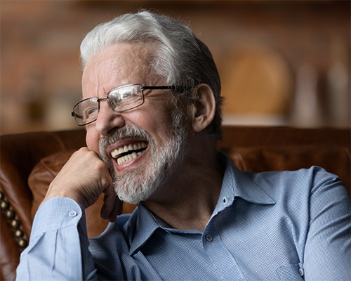 Senior man smiling on a leather armchair