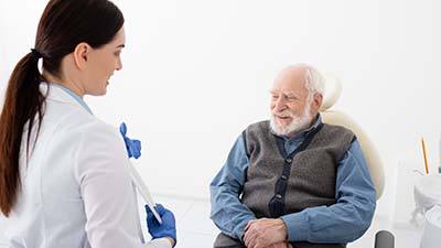 Dentist and senior man discussing candidacy for All-on-4 treatment