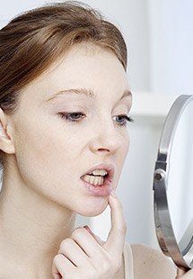 Woman looking at teeth in mirror