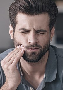 Man holding jaw in pain