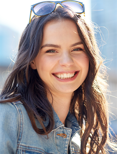 Young woman smiling outdoors on a sunny day