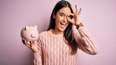 Smiling woman holding piggy bank