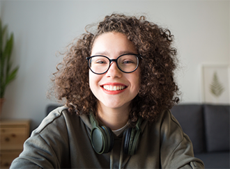 Smiling young woman with headphones around her neck