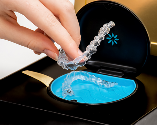 Hand placing a clear aligner in its case