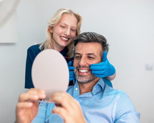 Dentist showing a patient his new smile in a mirror
