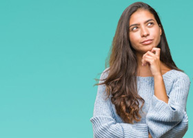 Woman tapping her chin in a questioning pose