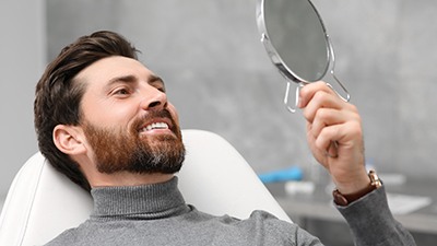 a man smiling after receiving a dental crown