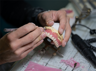 Dental professional working on a denture
