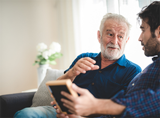 Man and his father talking on a couch