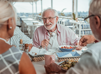 Group of seniors eating at a restaurant outdoors