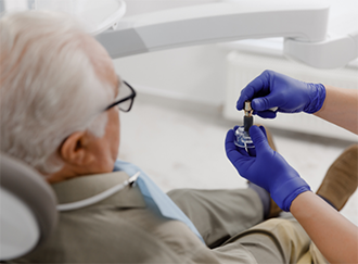 Dentist showing a dental implant model to a patient