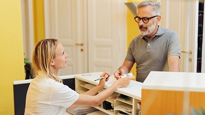 An older man paying the cost of dentures