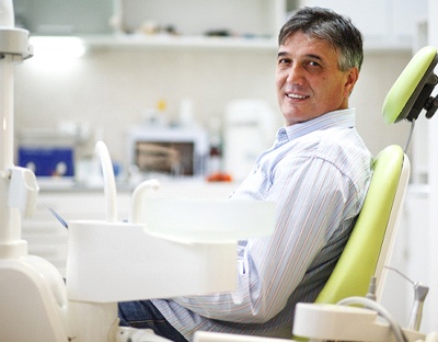 Middle-aged man sitting in dental chair looking at camera