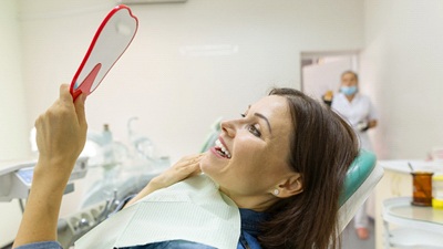 Using mirror to admire results of dental procedures