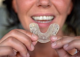 Woman holding a mouthguard in Irving