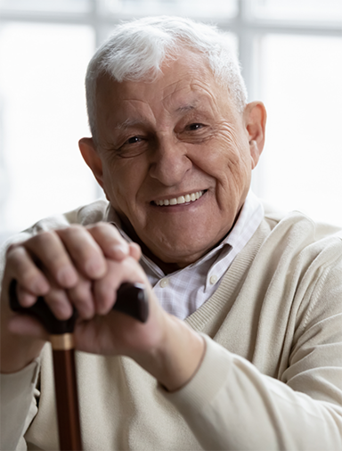 Senior man sitting and leaning on his cane