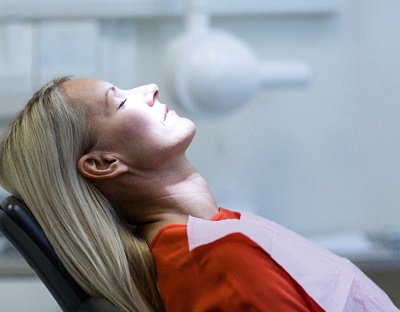 Woman with blonde hair relaxed while sitting in the dental chair