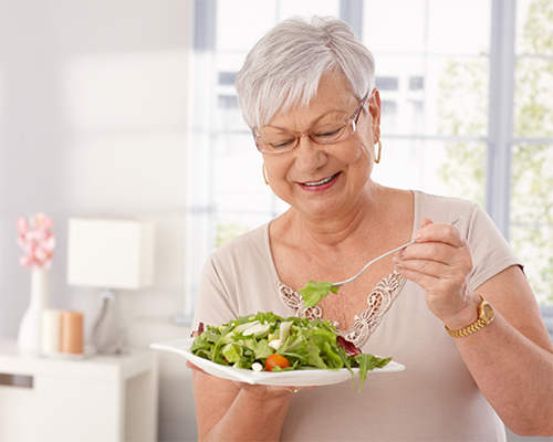 Senior woman eating salad