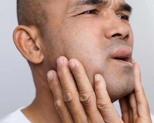 Man holding his face in pain