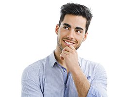 Man in blue collared shirt thinking about getting dental implants