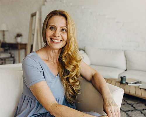 Blonde woman sitting on a white armchair