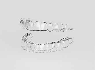 Two clear aligners against white background