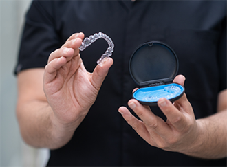 Dentist holding Invisalign and its case
