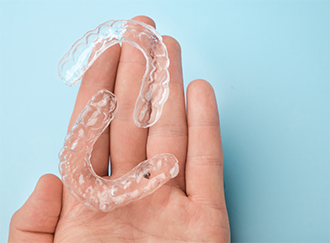 Hand holding two aligners