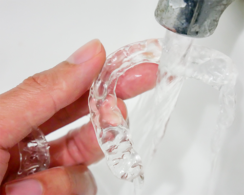 Running water over an Invisalign clear aligner