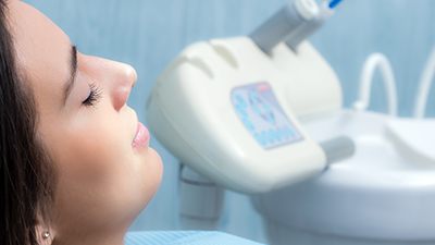 Woman with eyes closed receiving dental care