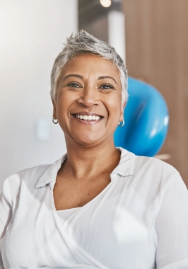 Woman with short gray hair smiling at the dentist