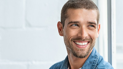 a man grinning after undergoing a smile makeover