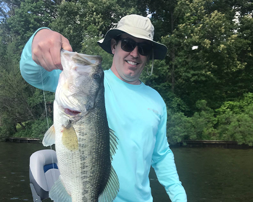 Doctor Roy holding a large bass fish he just caught