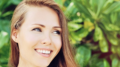 Woman's smile compared with tooth color chart