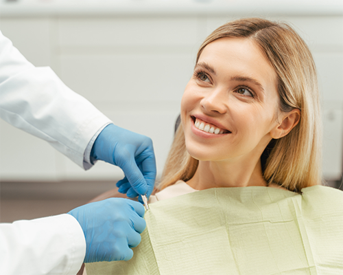 Blonde woman smiling at her dentist