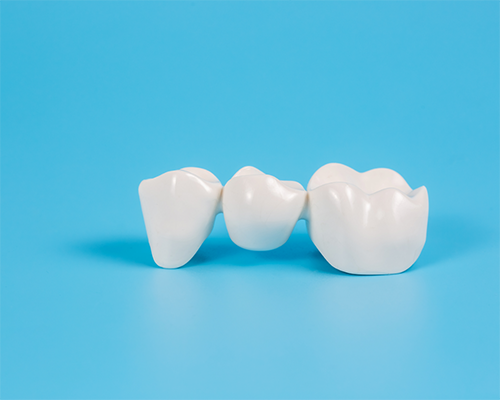 Dental bridge against light blue background
