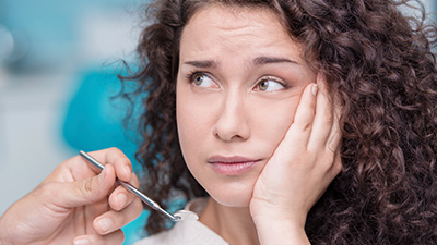 Woman holding cheek in pain