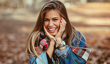 Smiling woman in a denim jacket outdoors