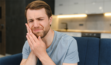 Man holding the side of his face in pain