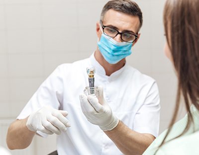 Dentist showing patient implant crown model