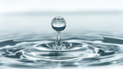 Water dropping into puddle of water