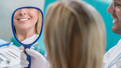 Woman looking at smile in mirror